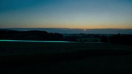 Aufkleber - The setting sun bathes a patchwork of farmland in warm light, casting long shadows across the fields and highlighting the contours of the landscape