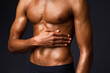 © Prostock-studio - Bodybuilding Concept. Strong athletic afro man with muscular naked torso touching his body over black studio wall