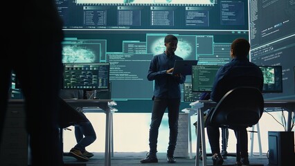 Group of governmental hackers analyzing digital threats on pc networks, using a big screen. Specialists working on collecting information, fighting against cybercrime and cyberterrorism. Camera B.