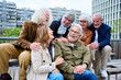 © CarlosBarquero - Group of six seniors grey hair joyful people having fun together sitting on bench in urban park. Cheerful mature Caucasian friends meeting talking funny enjoying free time laughing autumn day outdoors