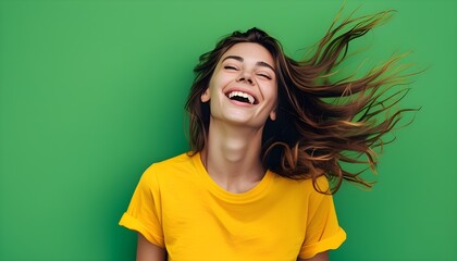 Carefree laughter of a joyful woman in yellow, hair flowing freely against a lively green backdrop