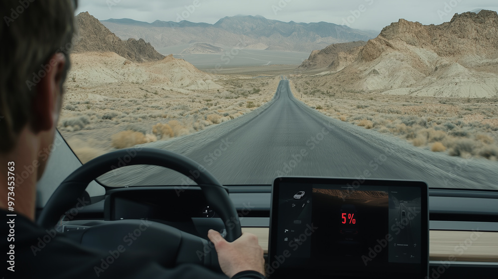 A man is driving a black EV on a desert road in the USA, with the view from the driver's seat looking at his car display, which shows a digital battery level showing "5%".