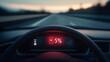 © Zhongyuan Chen - Close-up of an electric car dashboard with a digital display showing '5%' battery level, on the highway at dusk, with a blurred background.