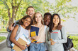 © Prostock-studio - Group of international happy students with books and notebooks having fun in park after studying, smiling at camera