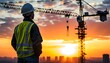 © 克 杜 - Engineer Observing Building Cranes Against a Warm Sunset Glow