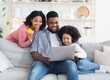 © Prostock-studio - Online Shopping Concept. Happy African American Family With Little Daughter Using Laptop And Credit Card At Home For Buying Goods In Internet
