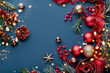 © Laima Gri - Festive Christmas card. Christmas tree branches with red decoration on blue background. Copy space, top view