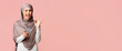 © Prostock-studio - Cool islamic app. Positive muslim girl in hijab winking and showing ok gesture while using smartphone, standing over pink background with copy space