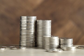 Wall Mural - Stacked coins on light table, closeup. Salary concept