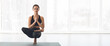 © Prostock-studio - A person performs an advanced yoga pose, balancing on one foot with the other leg lifted, in a bright indoor space during a morning practice,