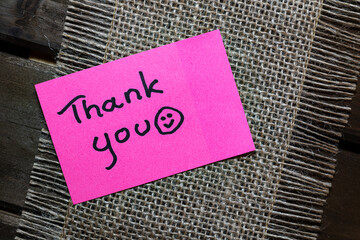 Thank you note written on a pink sticky note.