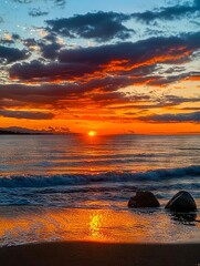 Poster - A sunset over the ocean with rocks in the foreground