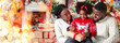 © Prostock-studio - Cute little black girl opening Christmas gift with her parents, sitting together in decorated living room.