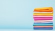 © BOJOShop - Stack of Colorful Folded Fabric on Blue Background
