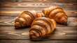 © lapeepon - Three freshly baked croissants on a wooden table , croissants, pastry, food, breakfast, French, bakery, delicious, golden