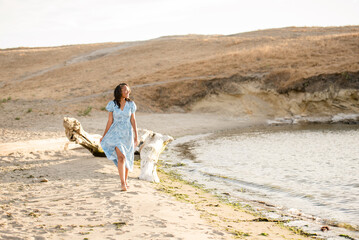 Wall Mural - Lady walking along the beach with a blue dress