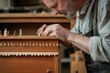 © Pornchai - An artisan carefully working on intricate wood details in a workshop, showcasing traditional craftsmanship and dedication.
