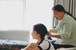 © Timeimage - Older Asian woman ties her daughter's hair