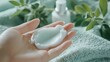 © Wittaya - Portraying Serenity: A Delicate Hand Applies Cream Amidst Soft Textures and Gentle Greenery