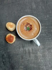 A cup of cappuccino coffee and snack bakpia. Food photography, flat lay.