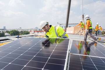 Wall Mural - Men technicians carrying photovoltaic solar moduls on roof of factory on the morning. Installing a Solar Cell on a Roof. Solar panels on roof. Workers installing solar cell power plant eco technology.