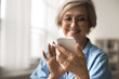 © fizkes - Close up cropped view smiling middle-aged woman looking at her smartphone, texting or chatting with family or friend, sharing messages, browsing social media networks, comfort and modern connectivity