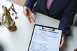 © crizzystudio - Female lawyer or judge consulting or discussing contract documents with clients Introduce correct legal contracts before signing contracts together within the office according to legal procedures.