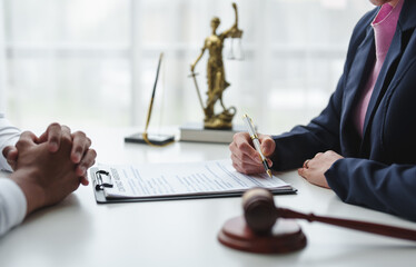 Female lawyer or judge consulting or discussing contract documents with clients Introduce correct legal contracts before signing contracts together within the office according to legal procedures.