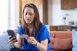 © Wavebreak Media - Using smartphone and holding credit card, asian woman making online payment at home
