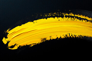 Wall Mural - bright yellow brush stroke of paint on black background
