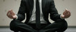 © Nathamanee - A man in a suit and tie is sitting cross legged and meditating