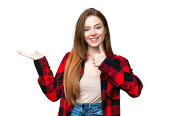 Wall Mural - Young pretty woman over isolated chroma key background holding copyspace imaginary on the palm to insert an ad and with thumbs up