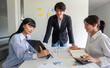 © wichayada - Young Business Team Collaborating on Marketing Plan in Modern Office Setting