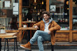 © Patcharaphon - Young fashionable man sitting and relaxing at cafe on weekend. Relaxation, lifestyle concept