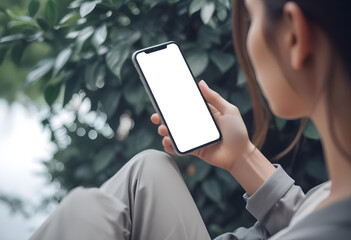 Cell phone white screen mockup, Woman hand holding mobile phone with blank screen while working at coffee shop. Business woman using smartphone, mockup for social media marketing