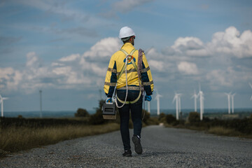 Fototapete - Back view of man engineers holding tools box and rope to maintenance working in wind turbine. Renewable energy power wind turbine. Technology protect environment reduce global warming problems.