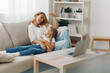 © SHOTPRIME STUDIO - Mother and child enjoying quality time on the couch with a laptop and coffee table in a cozy living room