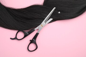 Poster - Black hair strand and professional scissors on pink background, top view