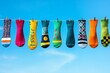 © Natalia - A row of colorful socks with various playful patterns hangs on a clothesline against a bright blue sky