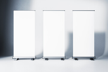 Wall Mural - Three blank roll-up banners in a studio with gradient background. 3D Rendering