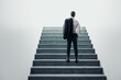 © Who is Danny - Businessman standing at the base of a concrete staircase, looking up.