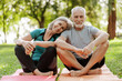 © Maria Vitkovska - Senior couple relaxing on yoga mat in park after exercising together