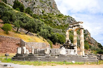 Stone remains of a tholos, a sacred circular building with columns in the sanctuary of Athena Pronaia in Delphi in Greece