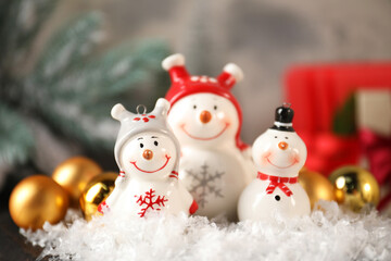 Wall Mural - Funny snowmen figures and Christmas decor on table, closeup