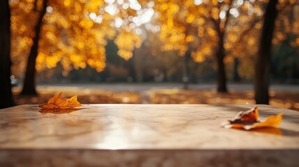 Wall Mural - A marble table adorned with autumn leaves, set against a blurred background of golden trees.