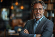 © Vertigo Images - A man in a blazer with a beard and glasses looks confidently at the camera.
