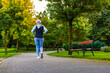 © Jacek Chabraszewski - Woman in casual wear and sunglasses walking in city park in early autumn. Back view