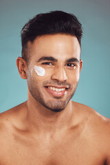 Canvas Print - Man, cosmetics and face cream in studio portrait for smile, pride or moisturizer by blue background. Person, model and happy with serum for facial glow, skincare or dermatology for health in Colombia