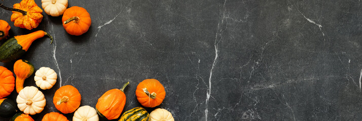 Aufkleber - Autumn corner border of pumpkins and gourds. Overhead view on a dark stone banner background with copy space.