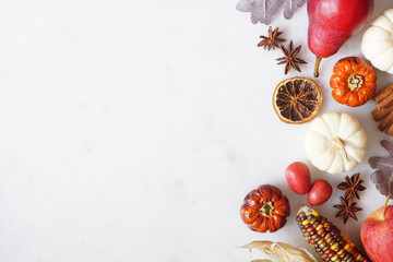 Poster - Fall border of pumpkins, leaves and autumn baking ingredients. Side border on a white marble background with copy space. Top down view.